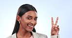 Face, peace sign and happy business woman in studio for winning, vote or celebrate success on blue background. Portrait, indian worker or show v icon, thanks and emoji for support, review or feedback