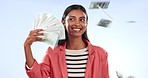 Woman, winner and money rain or fan for bonus, success and winning of lottery prize, profit or cashback in studio. Happy indian person with cash in air and financial freedom on a blue background