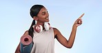 Headphones, pointing and woman face with fitness steps, workout and exercise with music in studio. Happy, athlete and training with gym list, information and choice for wellness and blue background