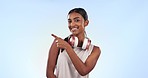 Headphones, pointing and woman face with fitness list, workout and exercise with music in studio. Happy, athlete and training with gym steps, information and choice for wellness and blue background