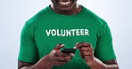 Volunteer face, cellphone and happy black man typing charity research, community service blog or waste management info. Studio smartphone, portrait or activist check Earth Day news on blue background