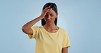 Stress, headache and face of Indian woman in studio with mistake, problem and fail with anxiety. Mental health, burnout and person with head pain, migraine and upset for crisis on blue background