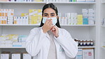 Pharmacist wearing a protective medical face mask for protection against a virus disease at a drugstore. Portrait of a female professional standing in pharmacy and shelves with medicine in background