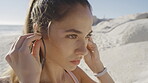 Fitness, face of woman and music at beach for motivation, strong mindset and focus for cardio training. Earphones, exercise and running at ocean for healthy goals, wellness vision and sports workout