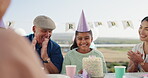 Birthday party, happy and people clapping hands for the girl to blow candles on her cake in the garden. Happiness, smile and young child and group of family in celebration at outdoor event together.