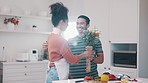 Home, couple and flower bouquet or surprise for anniversary, valentines day or birthday. A happy man and woman partner together in kitchen while cooking food and giving floral gift to celebrate love