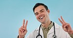 Peace, sign and portrait of doctor with support or fun hand gesture with smile isolated in studio blue background. Healthcare, professional and portrait of medical employee with emoji for cardiology