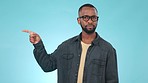 Doubt, pointing and face of black man in a studio with unsure, uncertain and choose gesture. Decision, choice and portrait of young African male model with trendy style isolated by blue background.