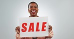 Sale, news and face of black woman in studio with poster, discount or cashback promo on grey background. Deal, billboard and portrait of happy African female model with banner, announcement or info