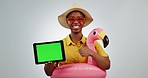 Tablet, thumbs up and smile of woman on green screen, pointing at tracking markers and isolated in studio on a white background mockup space. Travel, holiday and African person in inflatable flamingo