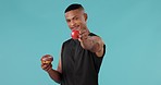 Apple, donut and choice with face of man in studio for nutrition, diet and wellness. Sugar, food and detox with portrait of person and fruit on blue background for eating, decision and option