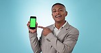 Green screen phone, happy and business man pointing at mobile application, recommendation or media service. Cellphone ads, online choice or studio person portrait with mockup space on blue background