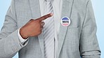 Vote pin, sticker and business man hand in studio with government and election decision. Pointing, administration and political party badge with choice and promotion for democracy and freedom support