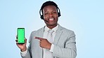 Call center, man face and hand pointing to green screen phone in studio for sign up info on blue background. Telemarketing, smartphone and portrait of consultant show contact us, platform or service