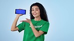 Woman, volunteer and phone green screen for website presentation, donation information and sign up in studio. Face of person on mobile app for NGO, volunteering or nonprofit space on blue background