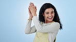 Woman, face and applause in studio for success, praise and congratulations to winner on blue background. Portrait of happy model clapping hands to celebrate winning achievement, support and feedback 