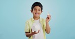 Piggy bank, cash and child face with money, savings and cash planning in a studio, Happy, portrait and young boy with allowance and safe for bills, wealth and budget with blue background and smile
