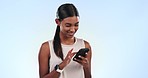 Woman, texting and reading with phone in studio, smile and thinking of communication by blue background. Girl, smartphone and happy with typing, web chat and contact for date on social network app