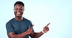 Man, happy and pointing on blue background in studio for mock up with promotion, offer or deal. Young, person or student with news, information or advice for graduates with finance, funding or jobs