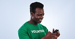 Volunteer, phone and happy black man reading, typing and scroll on charity outreach website, community service blog or post. Cellphone, studio news and activist texting NGO contact on blue background