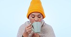 Drinking coffee, woman and relax with break, rest and hot drink from winter and sick in studio. Blue background, cup and tea with peace and calm with aroma and scent of a female person and virus