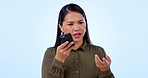 Phone call, speaker and woman with conversation, anger and communication on blue studio background. Person, girl and model with smartphone, speaking and conflict with network, connection and contact