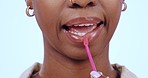 Black woman, face and lip gloss with kiss for makeup, beauty product or wellness routine in studio on blue background. Cosmetics, person and lipstick for self care, closeup and shiny lips with smile