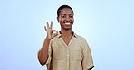 Face, ok sign and black woman with agreement, feedback and support with opportunity on blue studio background. Portrait, African person and model with hand gesture, review and icon with like or smile