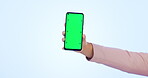 Person, hand and phone with green screen in advertising or marketing against a studio background. Closeup of mobile smartphone display, tracking markers or app on mockup space for advertisement