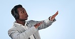 Black man, headphones and dancing to music in audio streaming against a blue studio background. Energetic African businessman with headset enjoying podcast sound, songs or playlist on mockup space