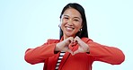 Asian woman, heart sign and studio for smile, face or love icon for review by blue background. Japanese business person, portrait and happy with symbol for decision, feedback or promotion for romance