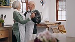 Senior couple, dancing or communication in home to love, care or celebration in marriage. Happy elderly man, woman or dancer in discussion to support, hug or relax together in retirement in kitchen