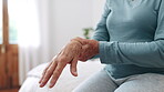 Hand, wrist pain or arthritis with a senior on the bed in a home for recovery from injury closeup. Anatomy, osteoporosis or fibromyalgia with an elderly person in the bedroom of an apartment