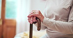 Cane, hands and elderly woman in home in bedroom for retirement in house. Walking stick, bed and closeup of senior person with a disability, stroke and crutch for injury, mobility support or balance