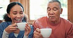 Coffee, smile or visit with a nurse and patient on a sofa in the living room of a home for assisted living. Face, tea or relax with a woman volunteer and senior man in an apartment for retirement