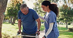 Senior man, walking and nurse help outdoor in garden, park or woods with woman, support and conversation in retirement. Caregiver, helping and guide elderly person with walker, physio and healthcare