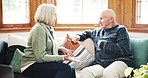 Stress, fighting and senior couple on a sofa with marriage problem, divorce or breakup at home. Upset, angry and elderly man and woman in retirement in argument with conflict in living room of house.