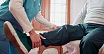 Physiotherapist hands, man and exercise for legs, joint pain and consultation for healthcare in clinic. Person, nurse woman and wellness for muscle injury, rehabilitation and assessment with support