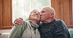 Hug, kiss and senior couple relax on a sofa with support, trust or gratitude in their home together. Love, security and old people embrace in a living room with care, romance or comfort in retirement