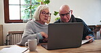 Senior, couple or documents with laptop for discussion, planning or investment for retirement in living room. Elderly, man or woman or technology, communication or research at table in lounge of home