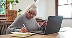 Senior, woman and writing with smartphone and laptop for planning, investment or schedule for retirement in living room. Elderly, person or notebook with technology and research at table in lounge