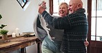 Happy old couple in living room, dancing and love in retirement, marriage commitment and fun together. Music, senior man and elderly woman in celebration with smile, romance and energy in apartment.