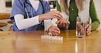 Patient, pills and hands of nurse with water in home helping woman with pharmaceutical, medicine and healthcare. Elderly, caregiver or person with medical drugs, glass and supplements in retirement