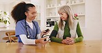 Healthcare, blood pressure and caregiver with old woman at table in apartment for test. Retirement, senior care and elderly person with nurse checking health for hypertension in house or nursing home