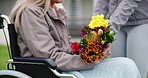 Senior, woman and nurse with flowers for support, empathy or care in wheelchair outdoor at nursing home. Elderly, person and caregiver with bouquet for sympathy, retirement and kindness in garden