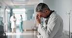 Stress, grief or fail with a mature doctor in a hospital looking unhappy for healthcare or medical. Depression, mistake or loss with a sad man medicine professional in a professional medicare clinic