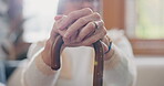 Walking stick, hands and senior woman with a disability in home, apartment or retirement with support for injury. Elderly, closeup or person with wood cane to help balance or mobility with arthritis