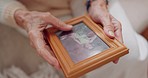 Frame, picture and hands of senior person for nostalgia, memories and thinking of past in home. Retirement home, elderly and closeup of photo to remember, mourning and depression with Alzheimer's