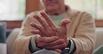 Closeup, hands and senior man with wrist pain, injury and inflammation with bruise, home and broken. Zoom, pensioner and elderly guy on a couch, fingers with ache and arthritis with sprain and strain
