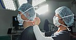 Surgery, hospital and doctors tie mask in operating room for medical service, preparation and operation. Healthcare team, safety scrubs and people with uniform for emergency, procedure and protection